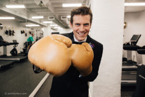 photo of a person in a tuxedo wearing boxing gloves.